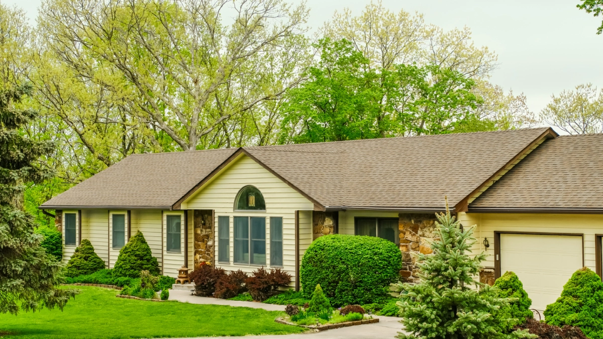 Ranch house with brown roof and green lawn.