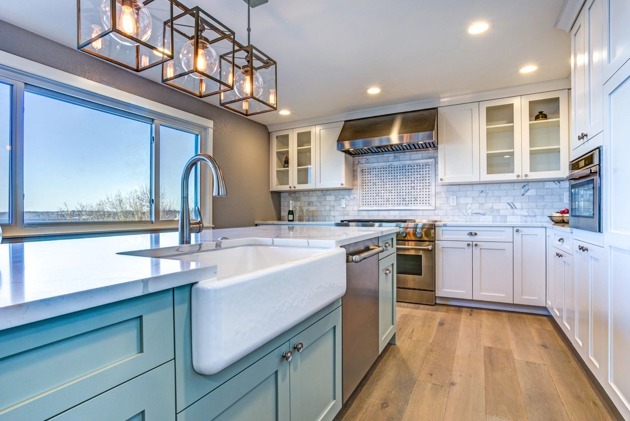 About 1 A kitchen with white cabinets and blue island.